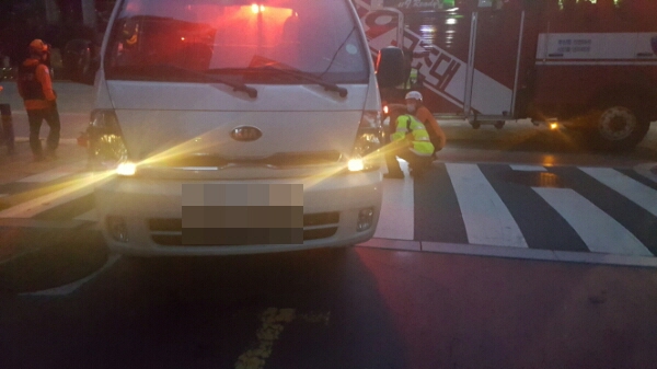 화물차량 밑으로 들어간 오토바이운전자를 구조하고 있다.(사진제공=부산지방경찰청)