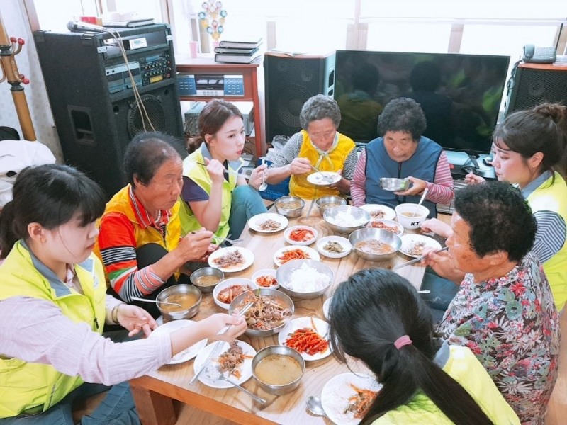 호산대 학생들이 봉사활동 후 마을 어르신들과 식사를 하고 있다.(사진제공=호산대학교)