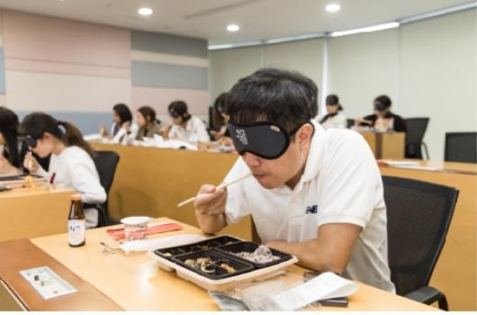 한국알콘 임직원들이 안대로 눈을 가린 채 식사를 하며 시력 장애의 어려움을 체험해보는 ‘Eyeless Lunch(어둠 속의 점심식사)’ 프로그램에 참여하고 있다. (사진=한국알콘)