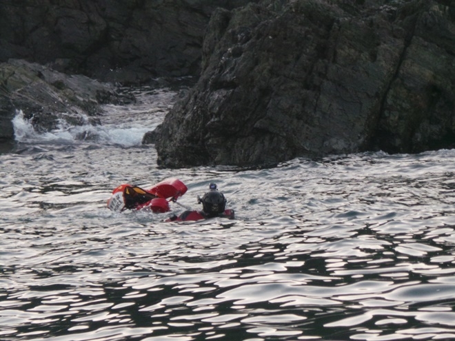 해경구조대원이 두사람에게 입힐 구명조끼를 가지고 갯바위로 수영해 가고 있다.(사진제공=울산해양경찰서)