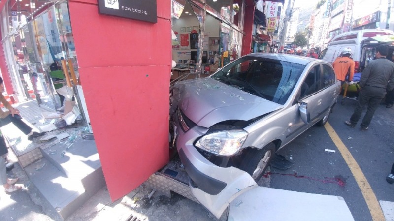 (무면허로 주차된 차량을 운전하다 보행자와 휴대폰가게 출입문을 충격한 모습. (사진제공=부산지방경찰청)