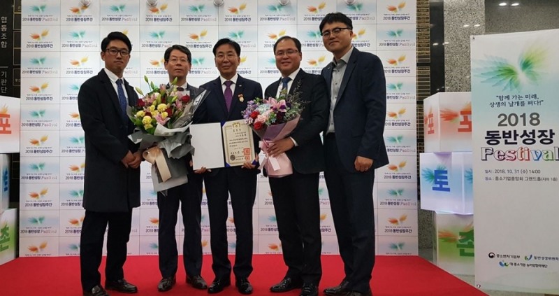 중소기업중앙회에서 열린‘2018 동반성장 주간 기념식’에서 대통령표창을 수상한 이종환 LX충북지역본부장(오른쪽에서 세번째)과 LX직원들이 기념촬영을 하고 있다. (사진=LX)