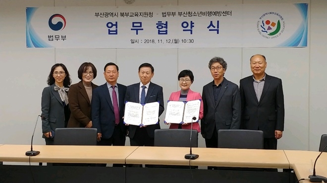 업무협약서를 내보이며 기념촬영을 하고 있다.(사진제공=부산청소년비행예방센터)