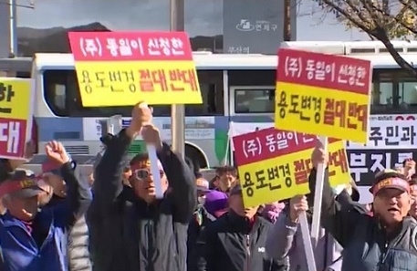 지난 23일 동일스위트가 매입한 부지 인근 마을주민들이 부산시청 광장에서 용도변경 절대반대 피켓을 들고 집회를 갖고 있다.(사진제공=천지일보)