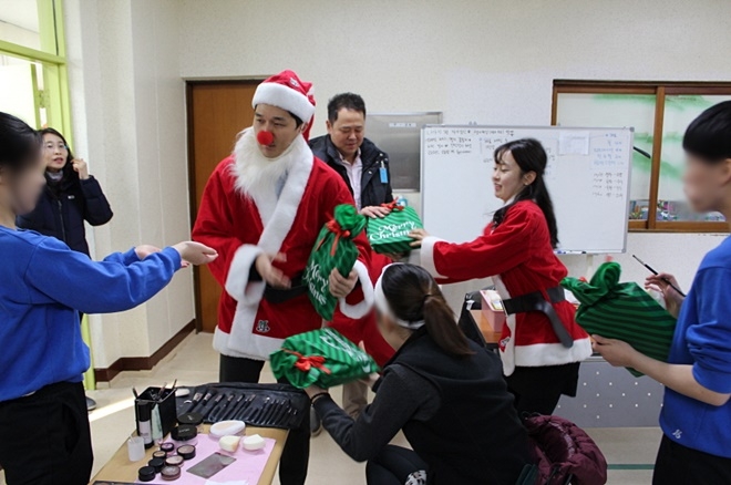 삼성SDS정규환 과장 등이 산타복장을 하고 학생들에게 선물을 나눠주고 있다.(사진제공=정심여자정보산업학교)