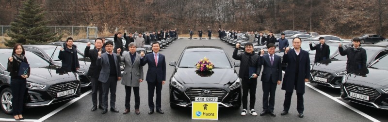 ▲ 휴온스글로벌 윤성태 부회장(중앙에서 왼쪽), 휴온스 엄기안 대표(중앙에서 오른쪽 두번째) 이하 임원들과 우수 영업사원 34인이 포상 차량 앞에서 기념촬영을 하고 있다.