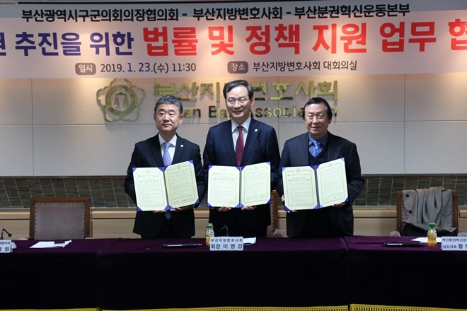 이명원 부산시 구·군의회의장협의회장, 이영갑 부산지방변호사회장, 황한식 부산분권혁신운동본부 상임대표가 업무협약서를 내보이며 기념촬영.