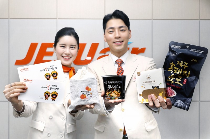제주항공 승무원들이 기내에서 나눠줄 세뱃돈 봉투와 돼지관련 아이템이 든 복주머니를 들고 환하게 웃고 있다. (사진=제주항공)