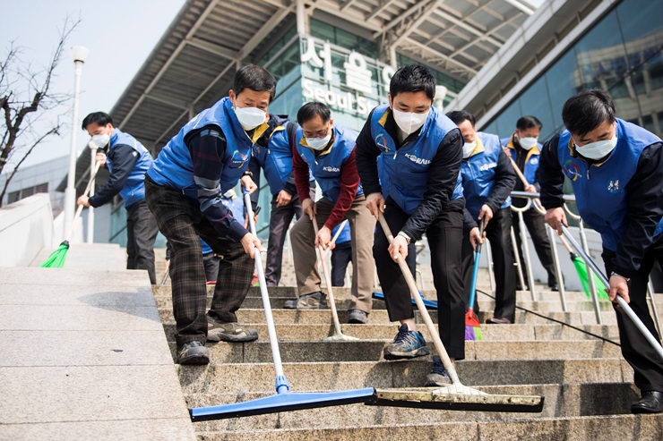 양운학 코레일 서울본부장(사진 앞줄 왼쪽)이 서울역 광장에서 서울 본부 전직원과 함께 물청소를 시행하고 있다(사진=코레일)