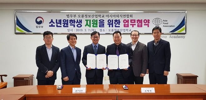 소년원학생 지원 업무협약서를 내보이며 기념촬영.(사진제공=오륜정보산업학교)