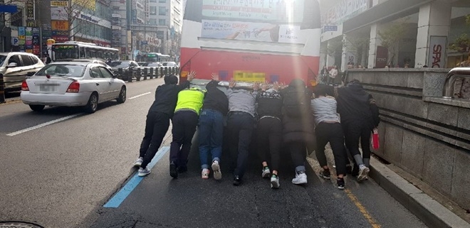 시민들과 경찰이 고장난 버스를 밀고 있다.(사진제공=부산경찰청)