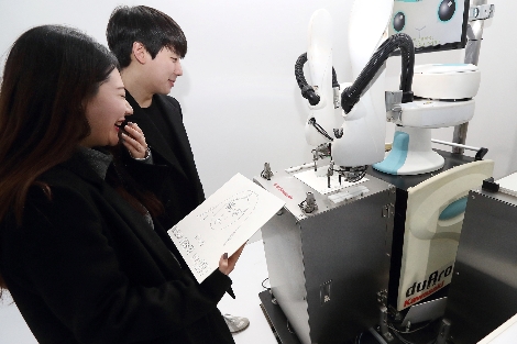 15일 광화문 북측광장에 오픈한 KT 5G체험관에서 5G로봇화가가 방문 고객들의 초상화를 그려주고 있다. 사진=KT