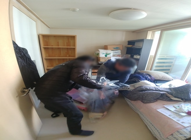 집안의 헌옷 등 생활쓰레기를 치우고 있다.(사진제공=부산서부준법지원센터)