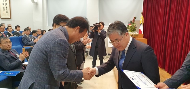 유정호 소장이 보호관찰위원들에게 법무부장관 명의 위촉장을 전달하고 악수를나누고 있다.