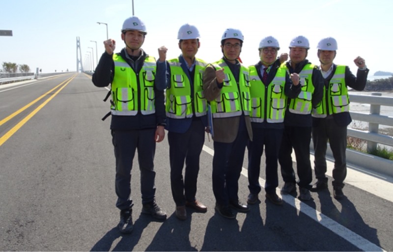 박영수 이사장(오른쪽에서 세 번째)이 교량 관리를 맡은 공단 직원들과 함께 천사대교를 배경으로 사진 촬영을 하고 있다.(사진=한국시설안전공단)