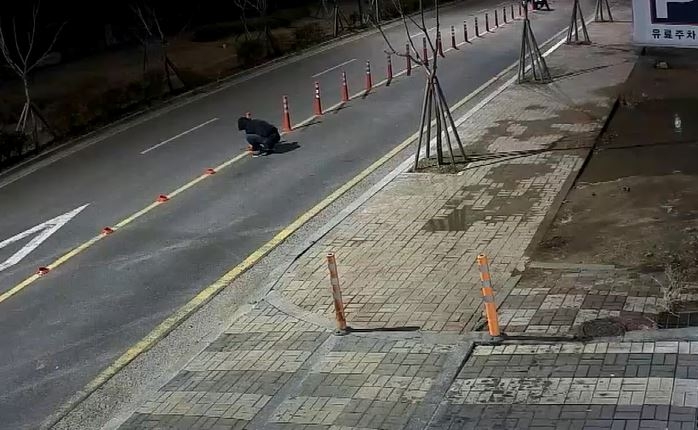 교통에 방해된다며 시선유도봉을 줄톱으로 절단하고 있다.(사진제공=부산경찰청)