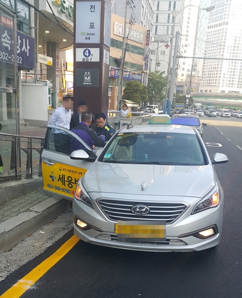 은행원이 택시에 두고 내린 4천만원을 택시기사가 되돌려 주고 있다.(사진제공=부산경찰청)