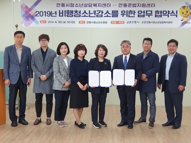 유정호 안동준법지원센터 소장(우측세번째)과 박소희 안동시청소년상담복지센터장(우측네번째) 등이 업무협약서를 내보이며 기념촬영.(사진제공=안동준법지원센터)