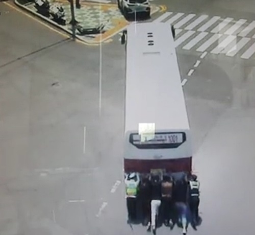 시민영웅들이 고장난 버스를 밀고 있다.(사진제공=부산경찰청)