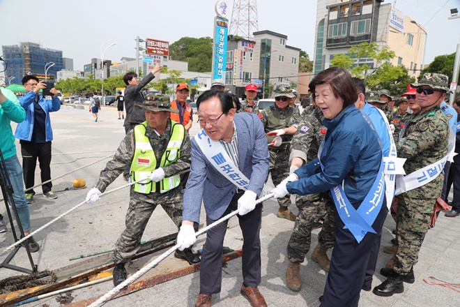 송철호 시장과 노옥희 울산교육감이 쓰레기더미를 잡아당기고 있다.