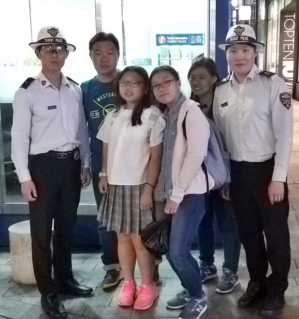 싱가폴 관광객이 택시 부당요금을 환수받고 고마워하며 관광경찰대 직원들과 기념촬영.(사진제공=부산경찰청)