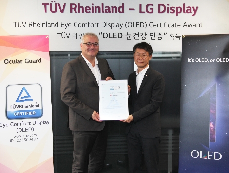 왼쪽부터 홀거 쿤즈(Holger Kunz) TUV 라인란드 제품인증 사업부문 회장과 LG디스플레이 TV사업부장 오창호 부사장이 기념촬영을 하고 있다. 사진=LG디스플레이