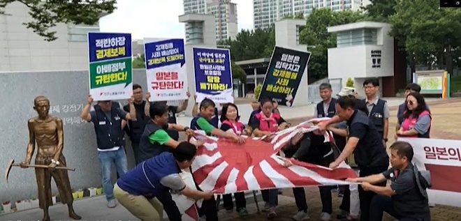 욱일기를 찢는 퍼포먼스를 하고 있다.(사진제공=민주노총울산본부)