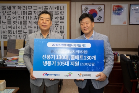 한국서부발전 송재섭 기획관리본부장이 가세로 태안군수에게 에너지취약계층을 위한 냉방용품을 지원하고 있는 모습. 사진=서부발전