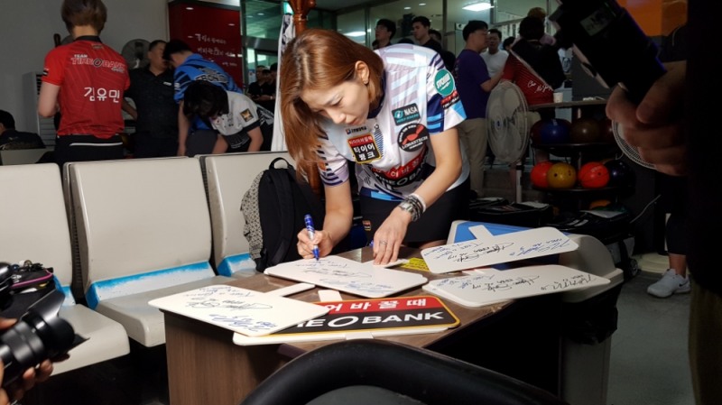 26일 결승 경기를 앞두고 팀타이어뱅크 선수들이 사인을 부탁하는 팬들에게 본인이 사인한 응원푯말과 타이어뱅크 우산을 증정하고 있다.(사진=타이어뱅크)
