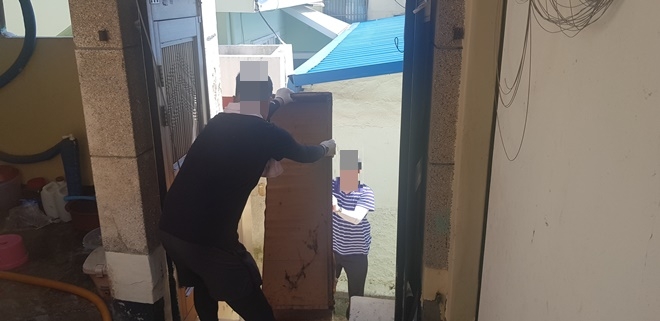 사회봉사대상자들이 주거지에 적치돼 있던 폐가구를 치우고 있다.(사진제공=부산준법지원센터)