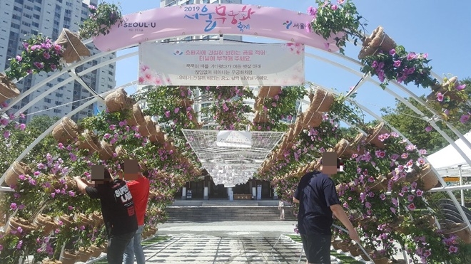 사회봉사대상자들이 무궁화 축제 행사를 위해 물을 공급하는 등 보조하고 있다.(사진제공=서울서부준법지원센터)