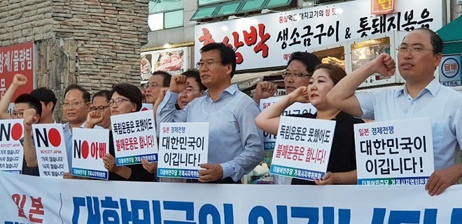문상모 위원장(앞줄 우측세번째) 등 참석자들이 경제보복 중단을 촉구하는 구호를 외치고 있다.(사진제공=더불어민주당거제시지역위원회)