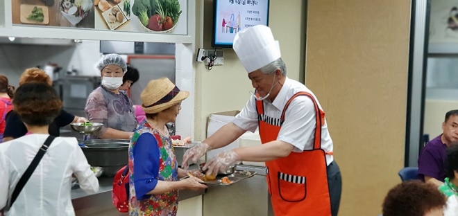 이상헌 의원이 배식봉사활동을 하며 안부를 묻고 있다.(사진제공=이상헌의원실)