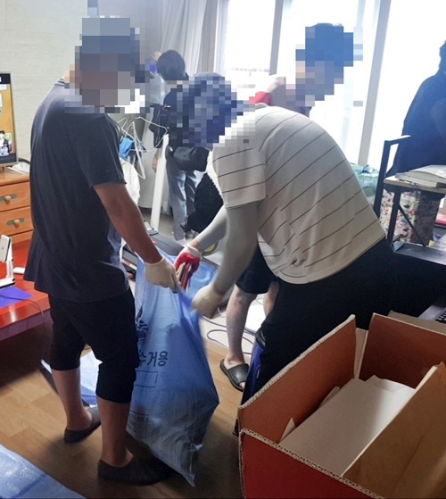 사회봉사대상자들이 주거지에 쌓여있던 폐의류 등을 치우고 있다.(사진제공=부산준법지원센터)