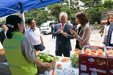 NH투자증권(대표이사 정영채)은 28일 여의도 본사에서 자매결연을 맺은 농가와 함께 직거래 장터를 개장했다. 정영채 사장(가운데)이 직거래 장터를 방문하여 농민들과 이야기를 나누고 있는 모습. 사진=NH투자증권