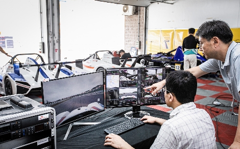 SK텔레콤 연구원들이 차고지에서 5G생중계로 운전 상황을 지켜보고 있다. 사진=SK텔레콤