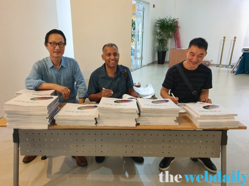 (왼쪽부터)한국 김근중작가, 인도 자가나스 판다 작가, 중국 궈웨이 작가가 도록에 서명을 남기고 있다/사진=김창만 기자