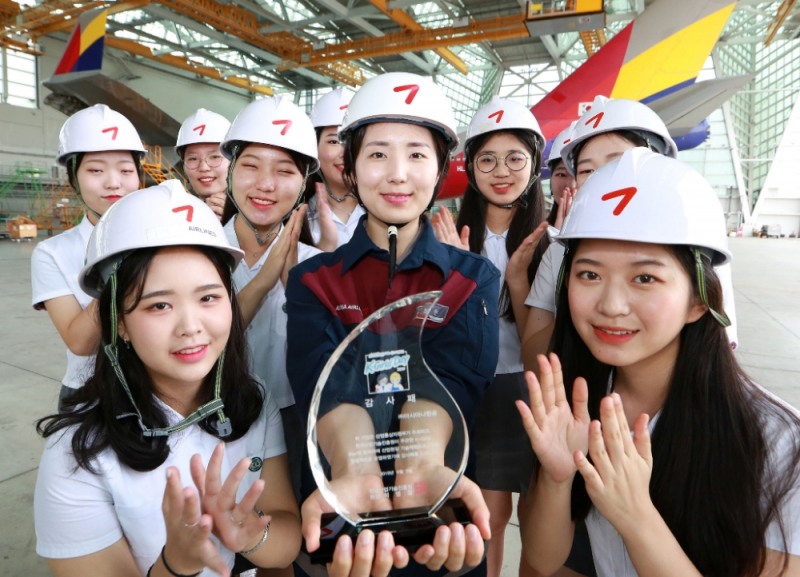 인천국제공항 제2격납고에서 진행된 'K-Girls Day' 행사에서 양명여자고등학교 학생들이 아시아나항공 여성 정비사 이보현 기술사(앞줄 가운데)와 감사패를 들고 기념촬영을 하고 있다.(사진=아시아나항공)