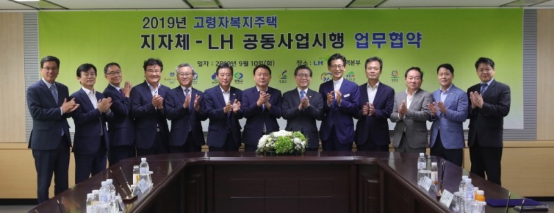 ‘고령자복지주택 공동사업시행 업무협약식’에서 변창흠 LH 사장(좌측 8번째) 및 12개 지자체장들이 기념촬영을 하고 있다.(사진=LH)