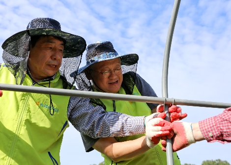 NH투자증권 정영채 사장(오른쪽)과 이강신 수석부사장(왼쪽)이 태풍 피해를 입은 버섯농가의 비닐하우스 재설치를 위한 뼈대 보강작업을 함께 하고 있다. 사진=NH투자증권