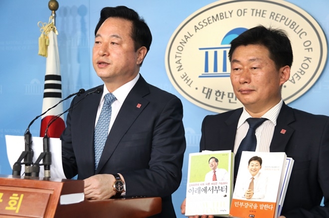 더불어민주당 김두관 의원(좌)과 임근재 경기경제과학진흥원 상임이사(우). 가슴에 ‘민부강국(民富强國)이 적힌 배지를 달고 있다. 임근재 상임이사는 민부론의 내용이 담긴 김두관 의원의 저서 「아래에서부터」와 임근재 상임이사의 저서 「민부강국을 말한다」를 들고 있다.(사진제공=김두관의원실)