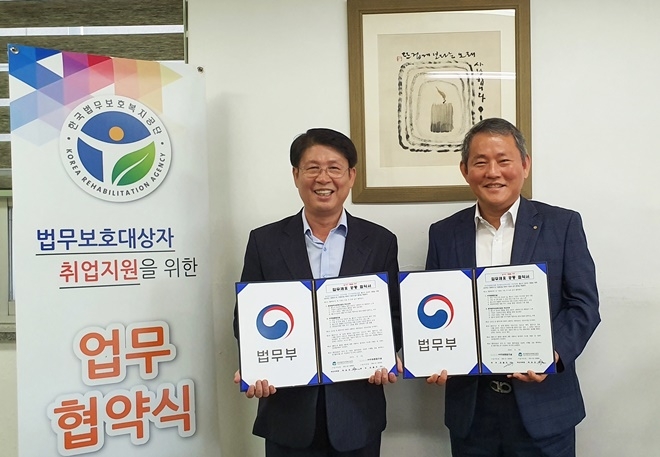 박호진 지부장(사진왼쪽)이 24일 오전 주원종합건설에서 전철우 대표와 업무협약서를 내보이며 기념촬영.(사진제공=한국법무보호복지공단부산지부)
