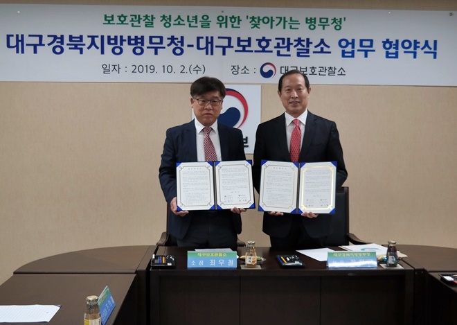 최우철 소장과 정창근 청장이 업무협약서를 내보이며 기념촬영.(사진제공=대구준법지원센터)