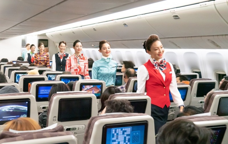 기내에서 객실승무원들이 지난 50년간 유니폼의 변화 과정을 탑승객들에게 선보이고 있는 모습.(사진=대한항공)