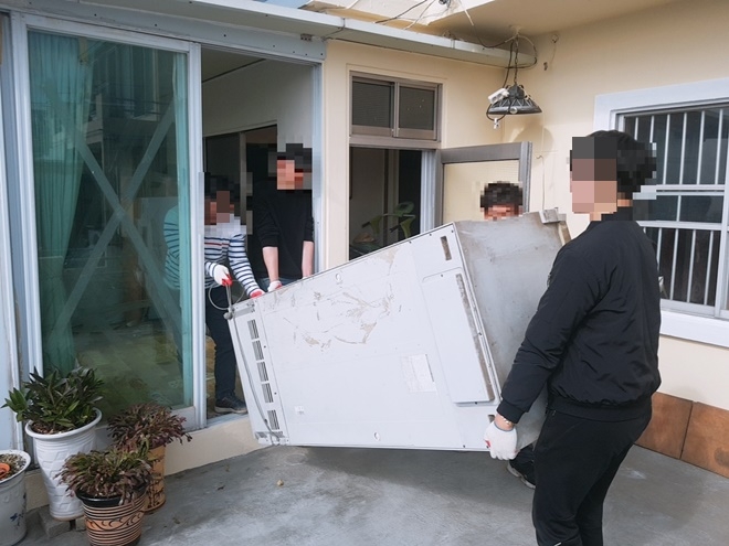 사회봉사대상자들이 폐가전제품을 치우고 있다.(사진제공=부산준법지원센터)