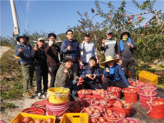 교도소직원들이 사과수확 일손돕기를 하고 기념촬영.(사진제공=안동교도소)