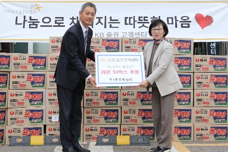 KB증권 권용욱고객센터장이 '나눔 플러스 힐링 디너' 기부 행사에서 사랑의 라면 50박스를 목1동 주민센터에 전달 후 이명신 목1동장과 기념촬영을하고 있다. 사진=KB증권