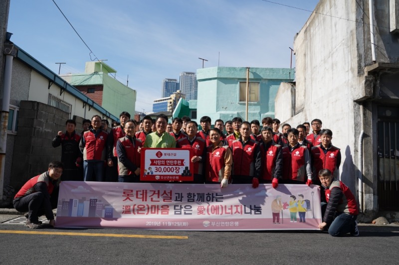 롯데건설 샤롯데 봉사단이 사랑의 연탄 나눔 봉사활동 기념촬영을 하고 있다.(사진=롯데건설)