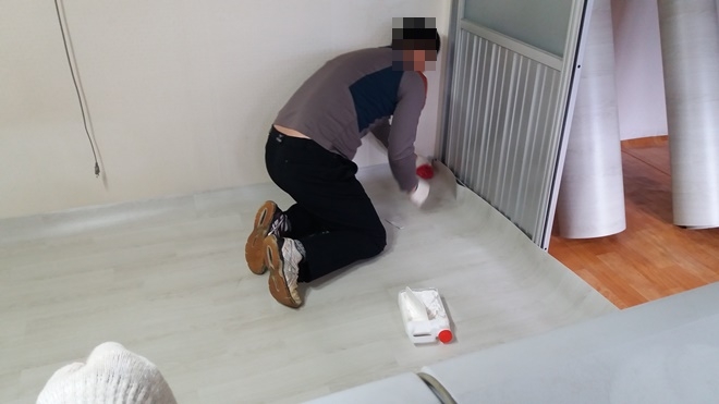 사회봉사대상자가 장판을 교체하고 있다.(사진제공=논산준법지원센터)