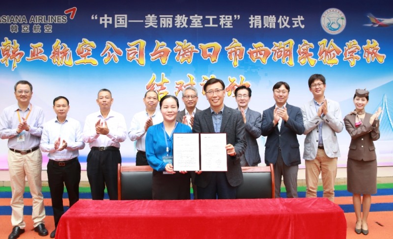 자매결연 행사에서 정성권 아시아나항공 중국지역본부장(앞줄 오른쪽), 펑쑤루 시후실험학교 교장(앞줄 왼쪽), 왕신커 하이커우시 외사판(뒷줄 왼쪽에서 네번째), 김창남 광저우 총영사관 부총영사(뒷줄 왼쪽에서 다섯번째)가 아시아나항공 임직원 및 하이커우시 정부 관계자들과 함께 기념촬영을 하고 있다.(사진=아시아나항공)